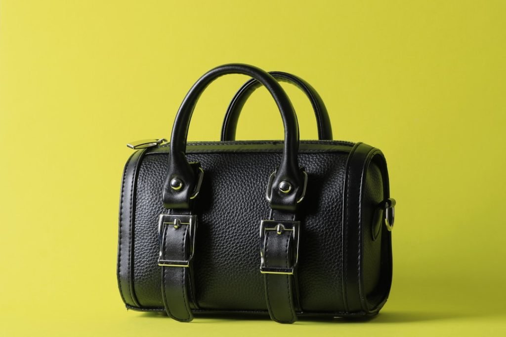 a-black-leather-bag-on-a-yellow-background-lnbuokz2glm