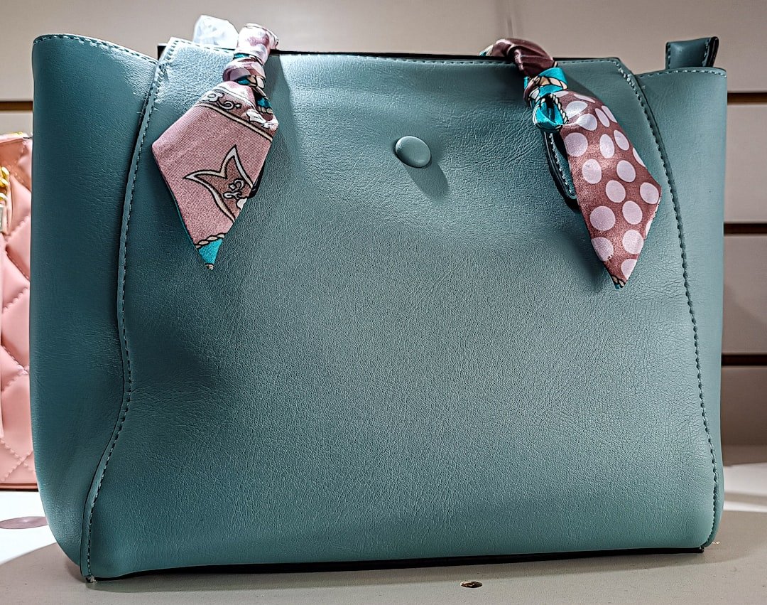 our-story-02 a-blue-purse-with-a-pink-polka-dot-scarf-on-it-9nih-ekeqx4