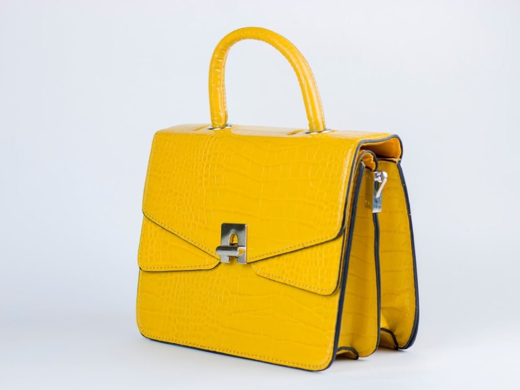 a-yellow-handbag-with-a-handle-on-a-white-background-pfyljnniz-c