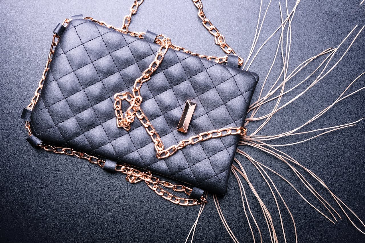 our-mission-01 Stylish black quilted purse with gold chain detail, perfect for fashion and elegance.