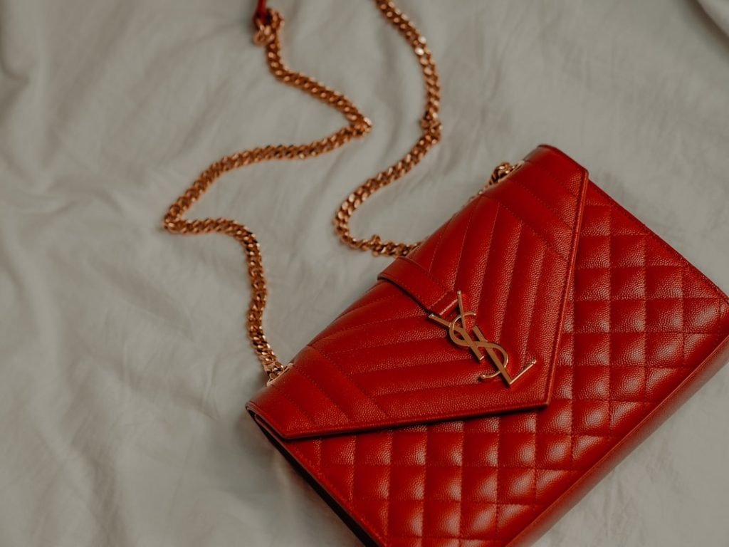 red-leather-sling-bag-on-white-textile-r2ddxvsnxkm